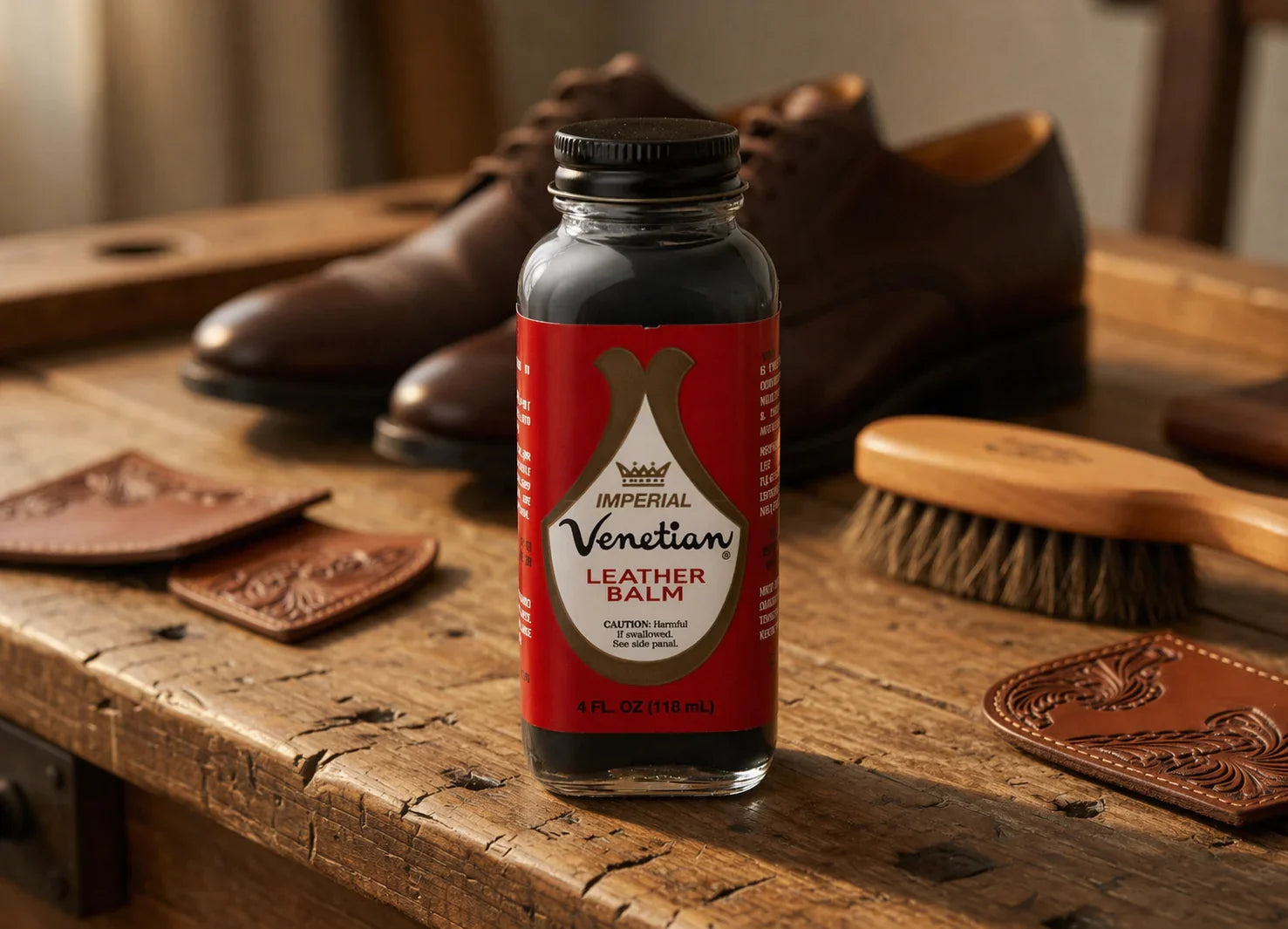 Venetian leather balm bottle on rustic table with leather shoes, brush, and leather patches
