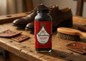 Imperial Venetian Leather Balm bottle on rustic wood with brown leather shoes and brush, for shoe care and conditioning