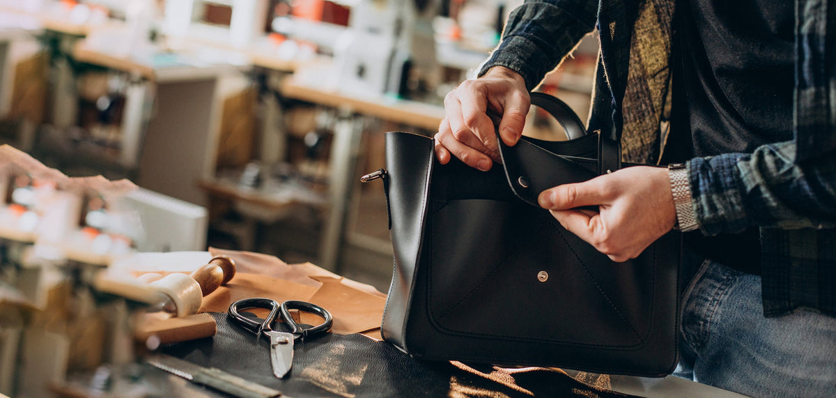 Leather bag repair with professional tools in workshop