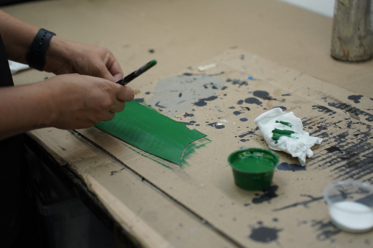 ShoeMedic technician hand-matching green leather colour for restoration
