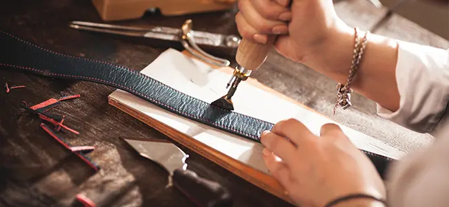 Cutting leather strap with scissors