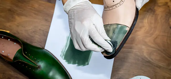 Green shoe dyeing with white gloves